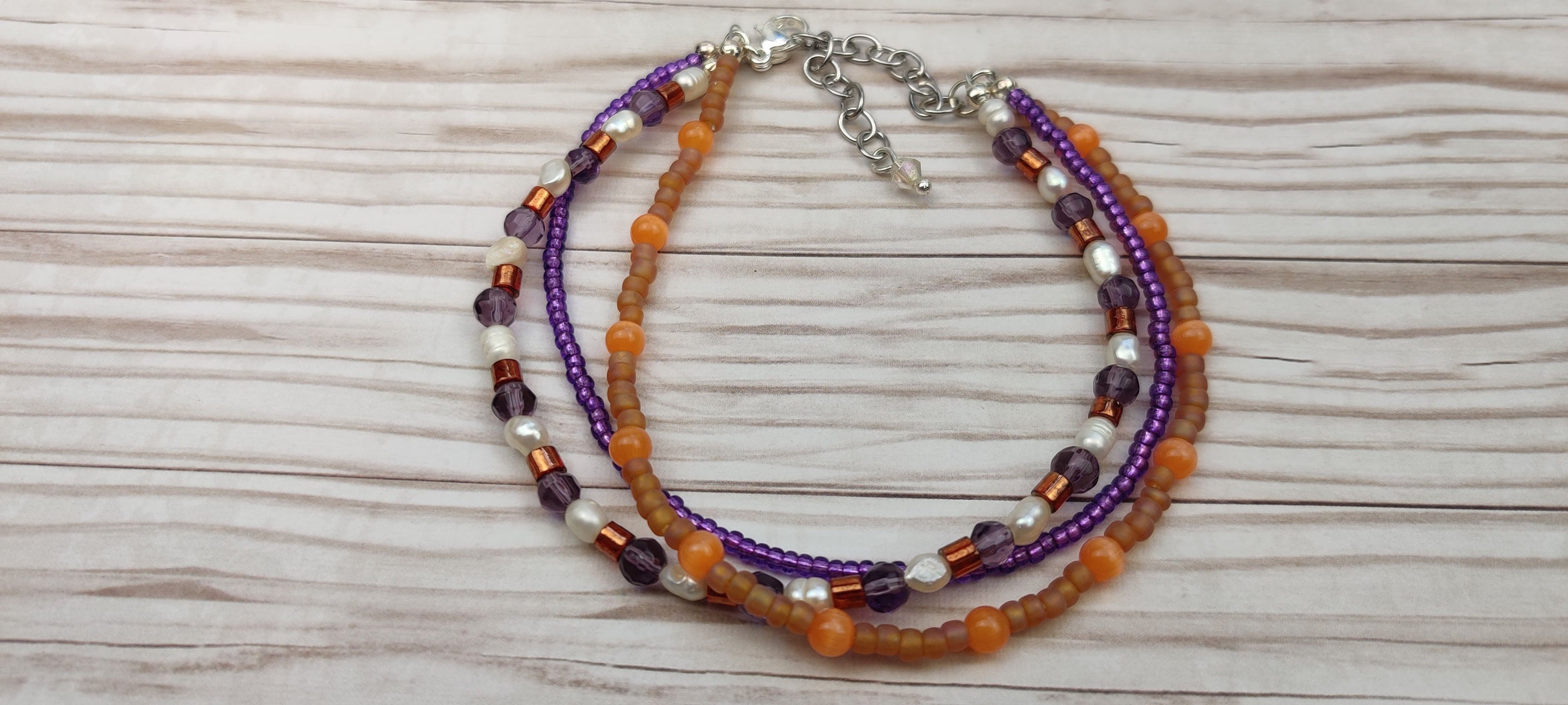 Three Strand Orange, Purple, and Freshwater Pearls Bracelet with Gold, Brown, and Black Glass Beads
