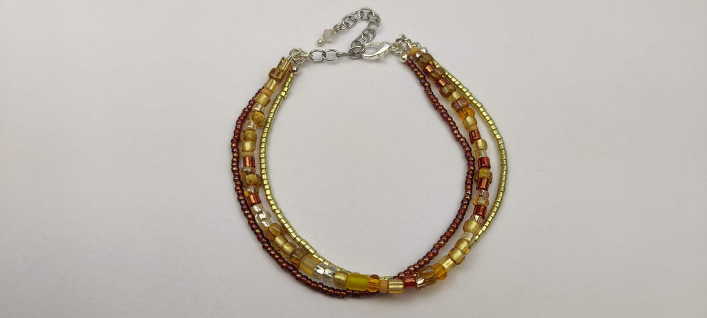 Three Strand Bracelet with Gold, Brown, and Beige Glass Beads