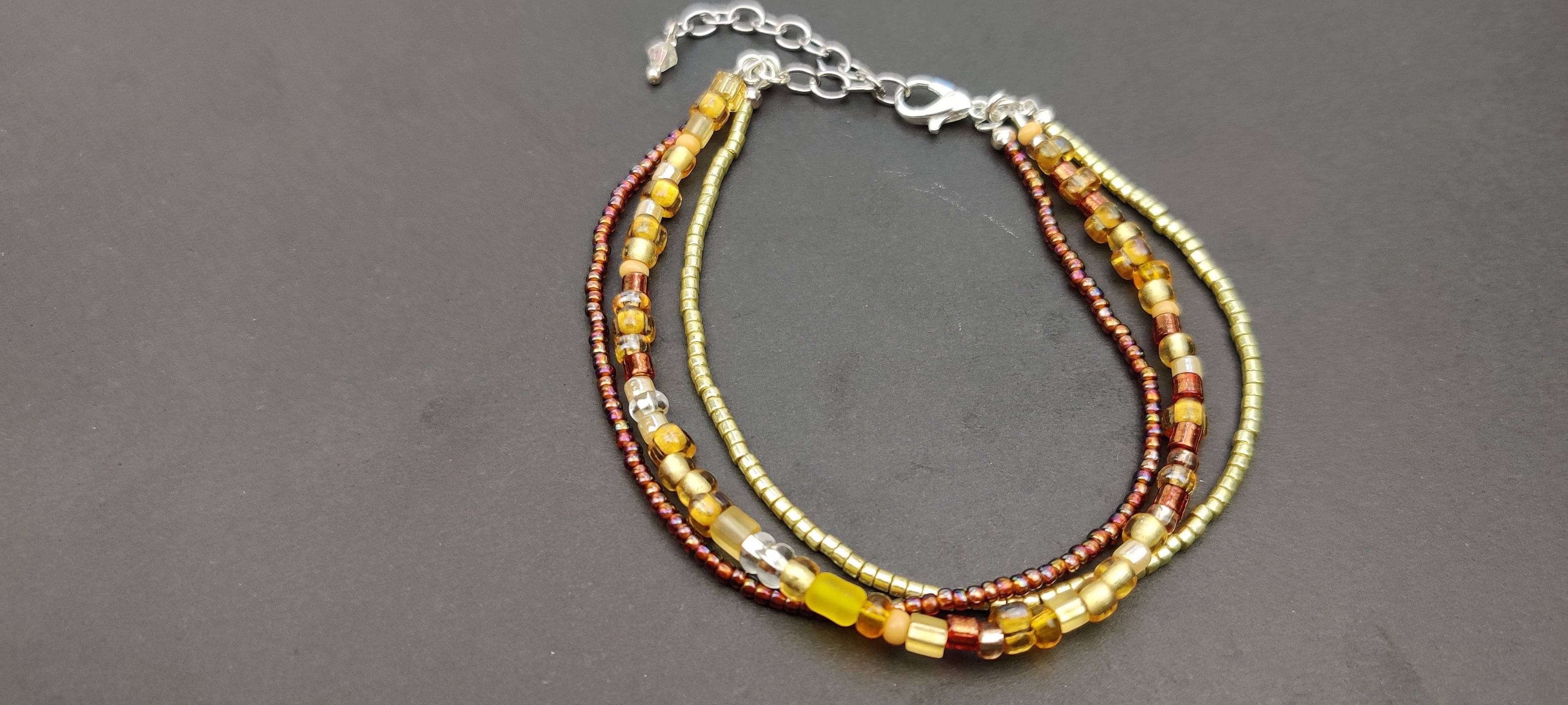Three Strand Bracelet with Gold, Brown, and Beige Glass Beads