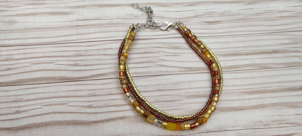 Three Strand Bracelet with Gold, Brown, and Beige Glass Beads