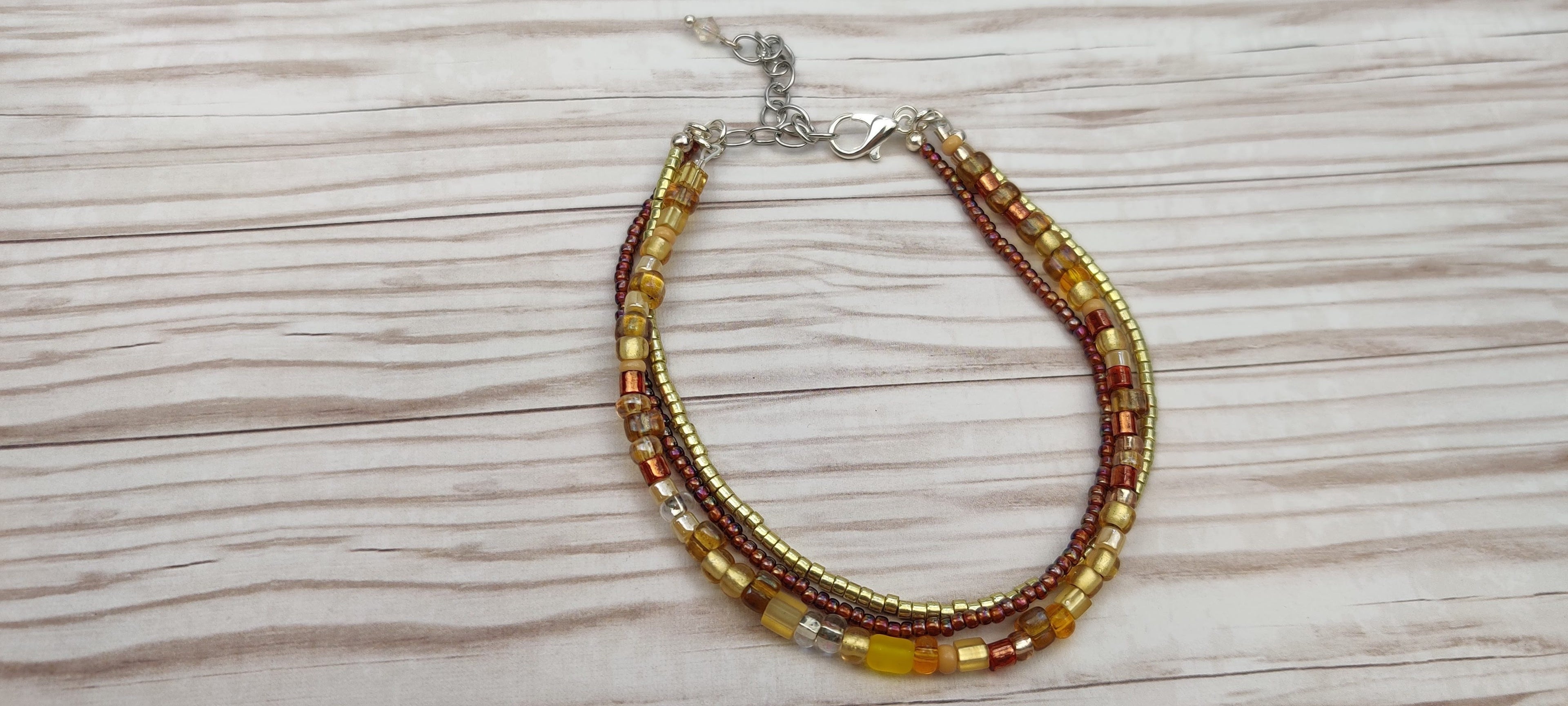 Three Strand Bracelet with Gold, Brown, and Beige Glass Beads